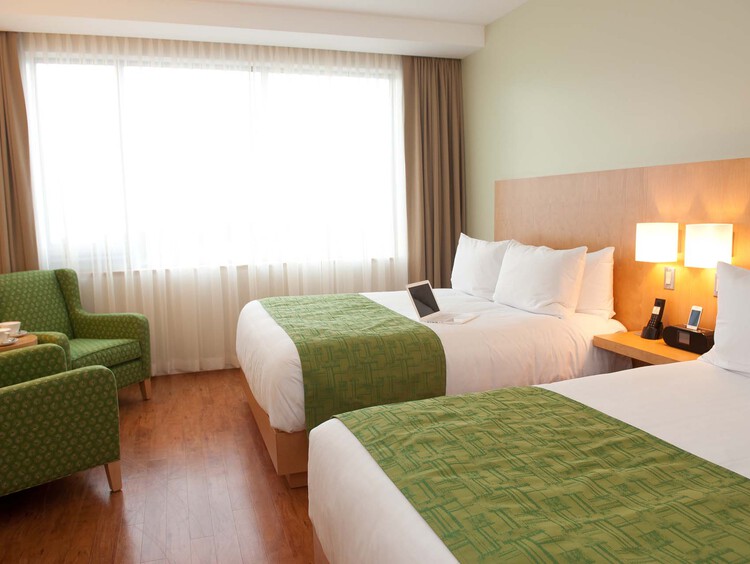 Guest bedroom with two queen beds and two armchairs