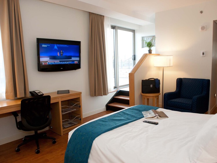 Terrace King room with a king bed, work desk, wall-mounted TV, and armchair