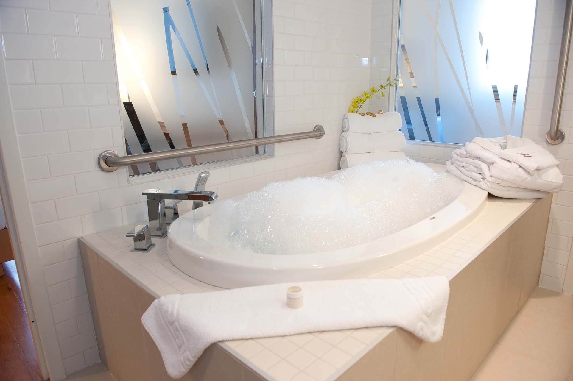 A bathroom with a tub with a grab bar