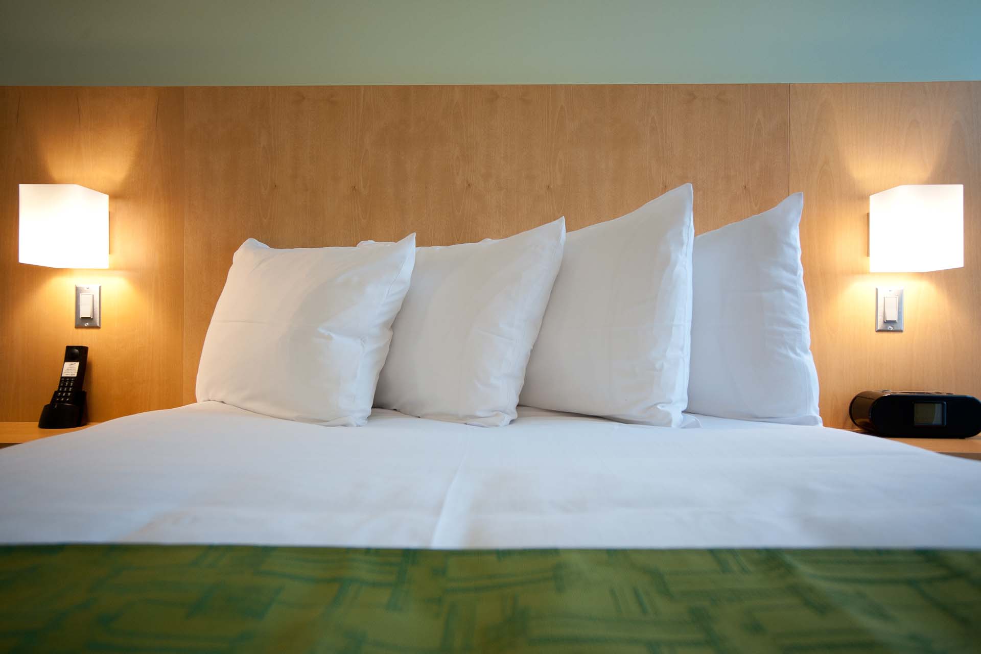 Closeup of a queen bed with four pillow