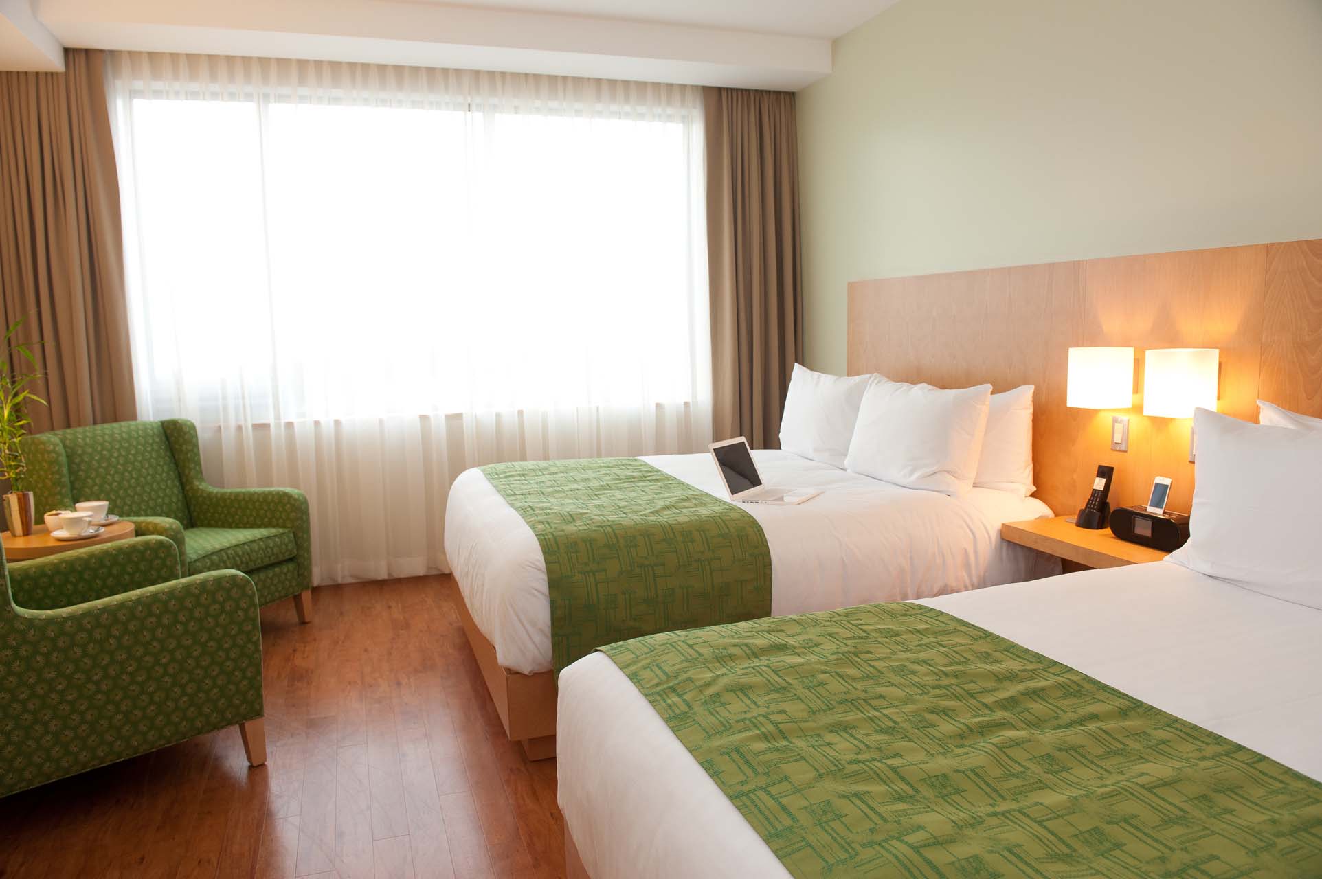 Guest bedroom with two queen beds and two armchairs
