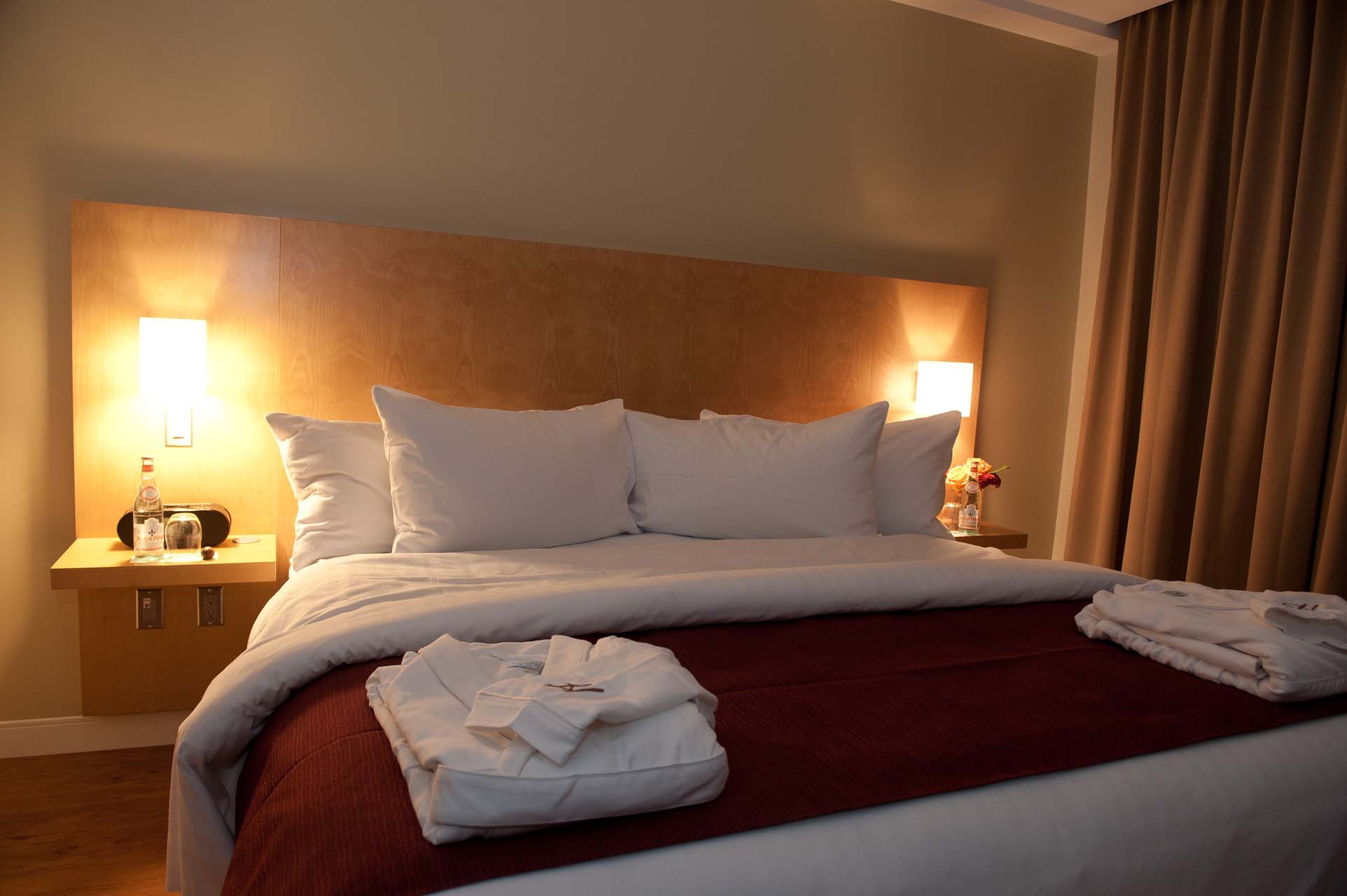 Two robes on top of a king bed