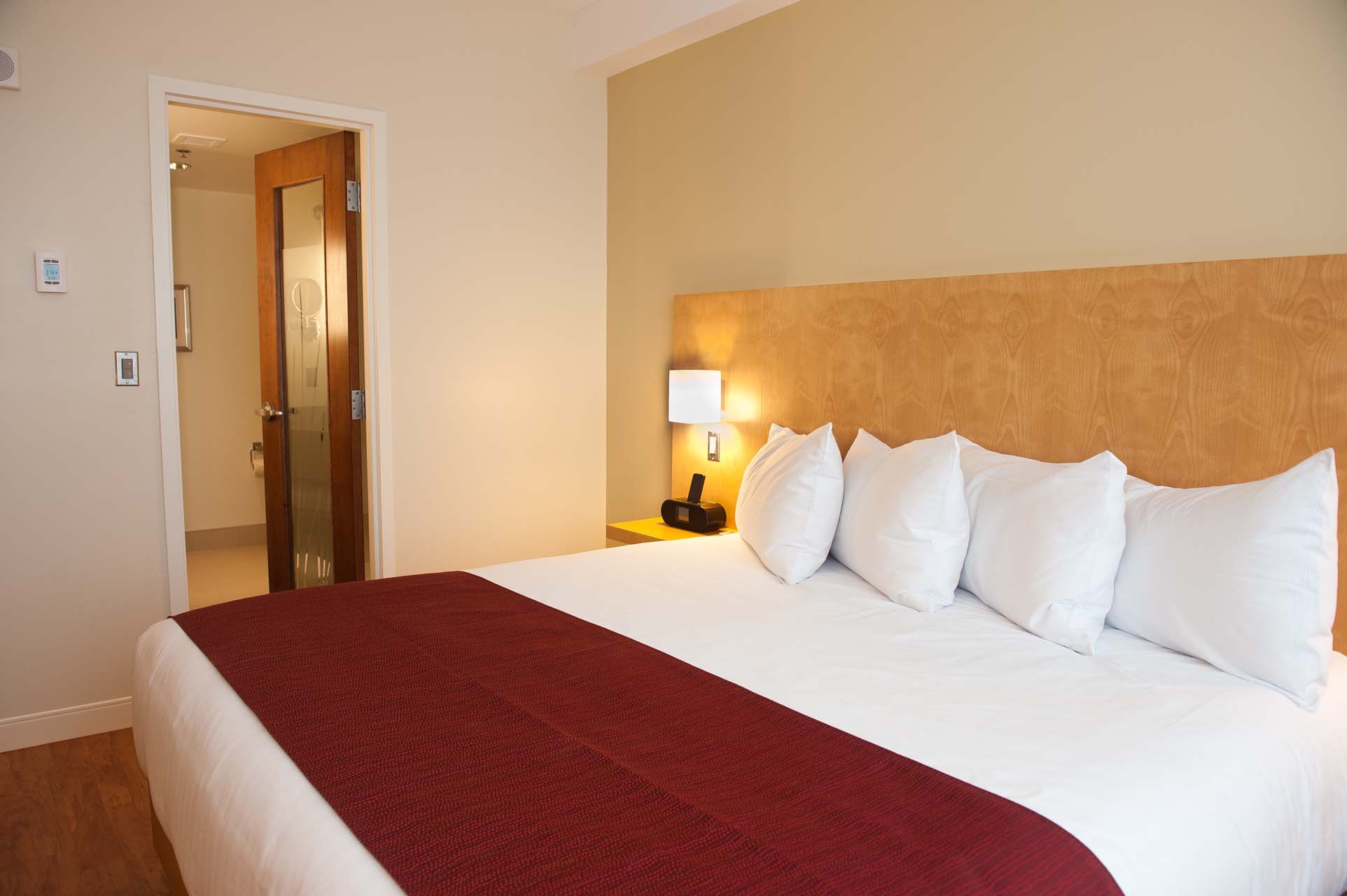 A king bed beside a door
