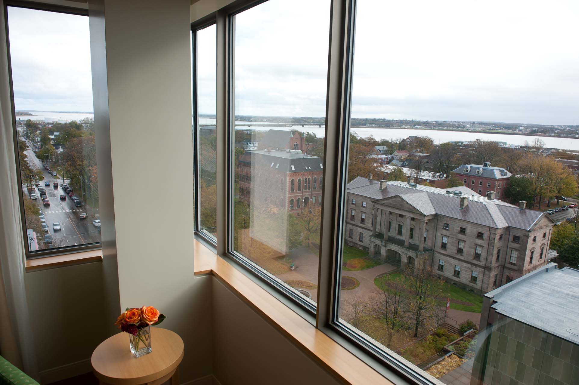 A bedroom window with a view of the city