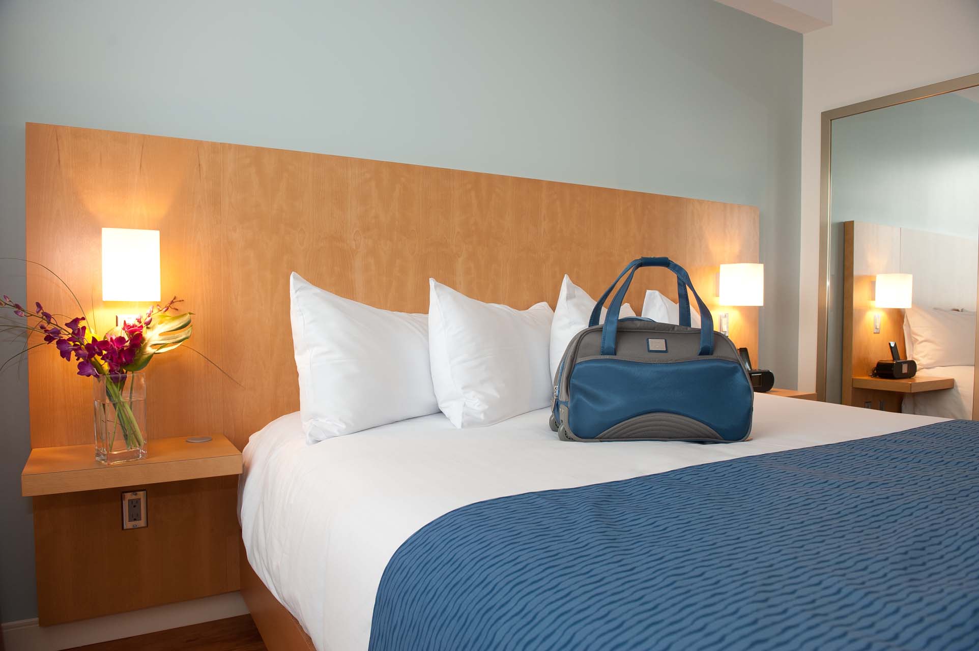 A blue bag on top of a king bed