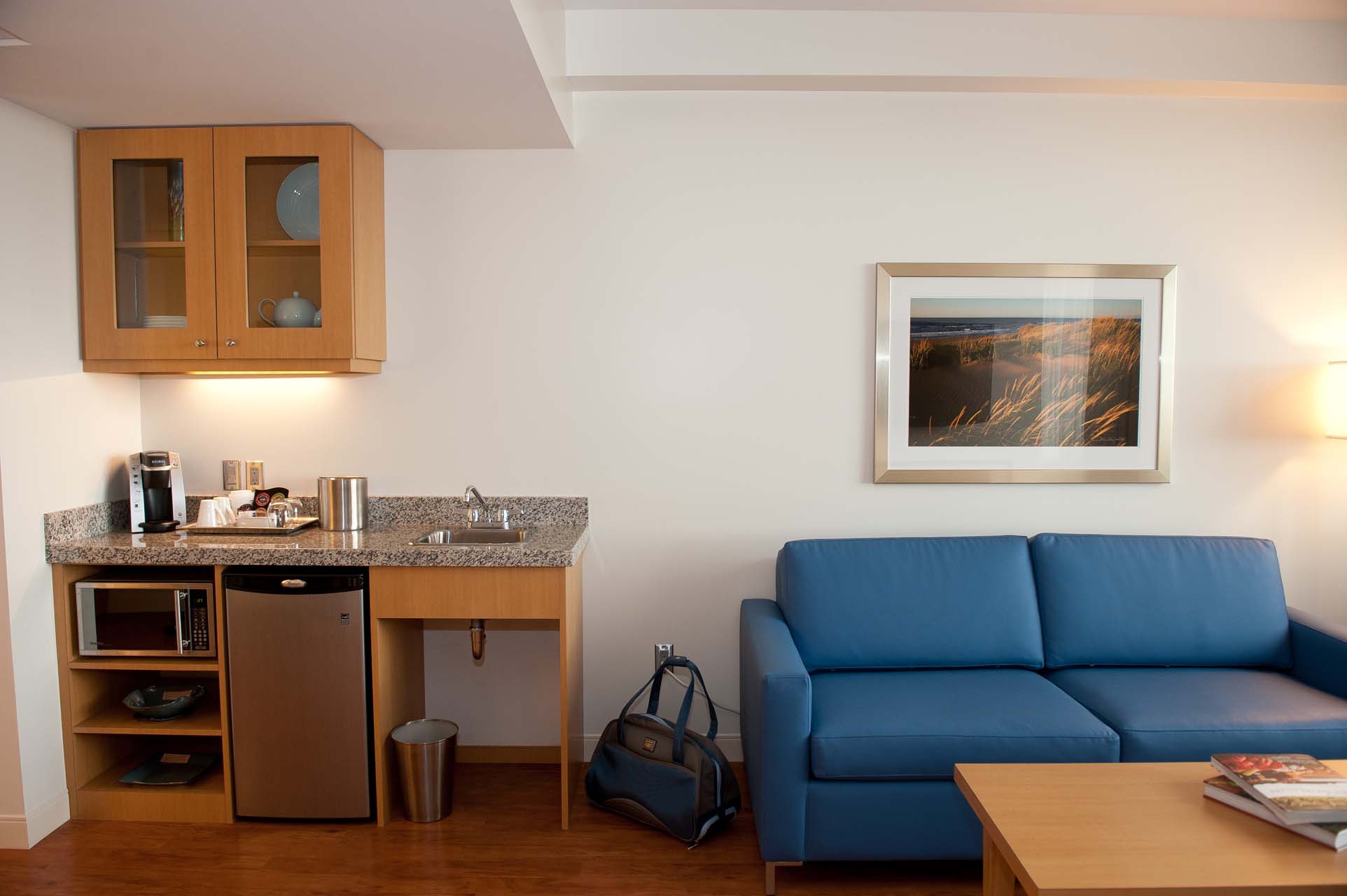 A living room with a blue sofa and a sink area