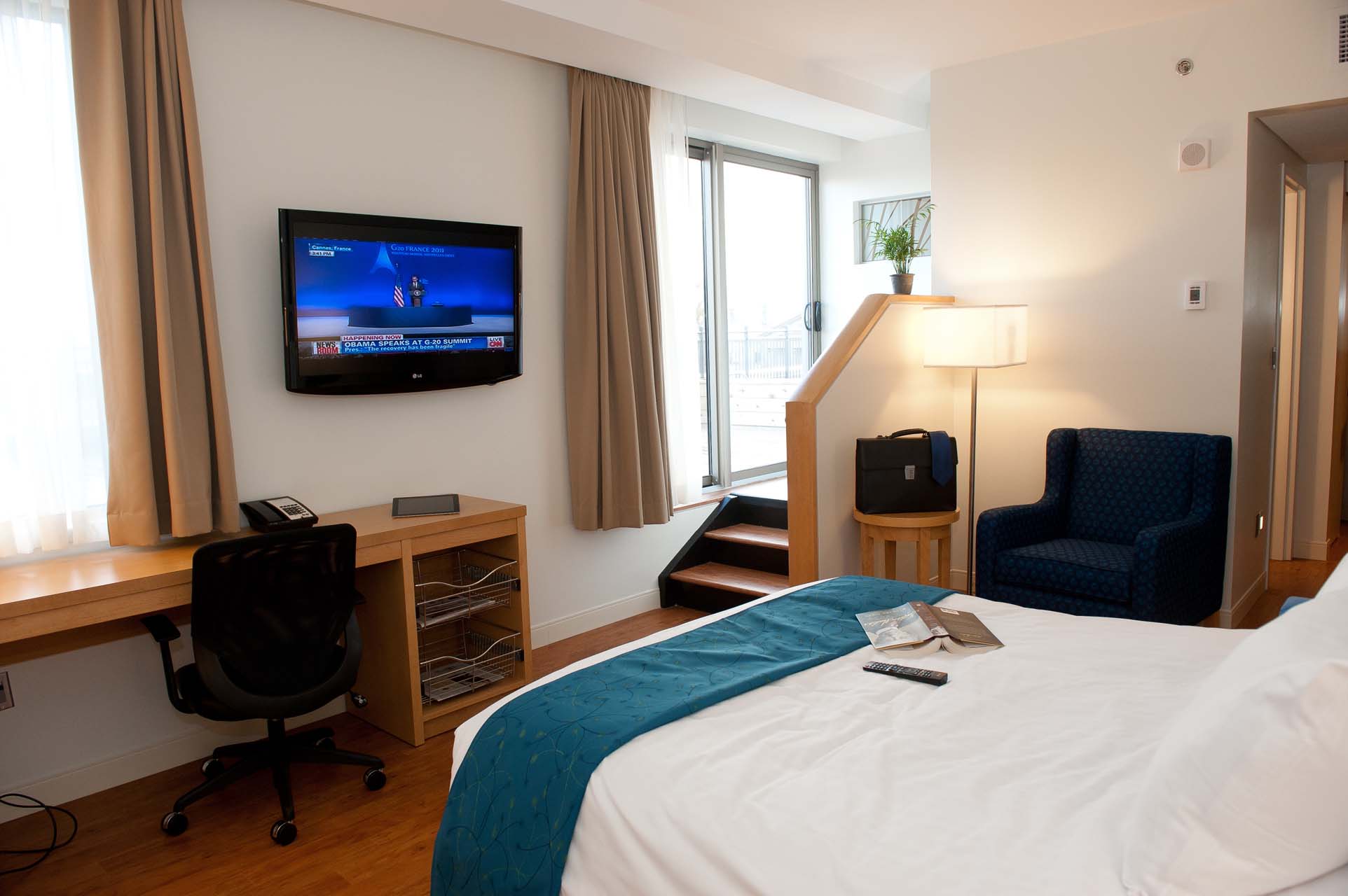 Terrace King room with a king bed, work desk, wall-mounted TV, and armchair